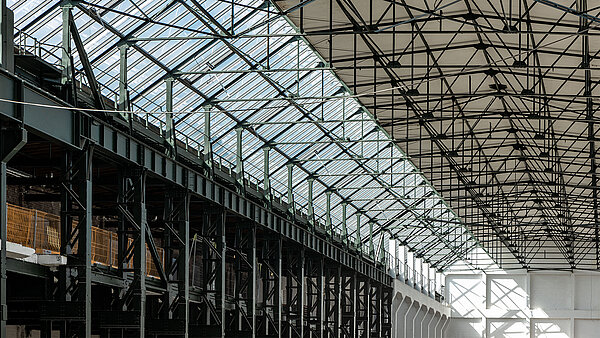 Innenansicht des Factory Campus Düsseldorf mit Glasdach, Stahlträgerkonstruktion und industriellem Charme.