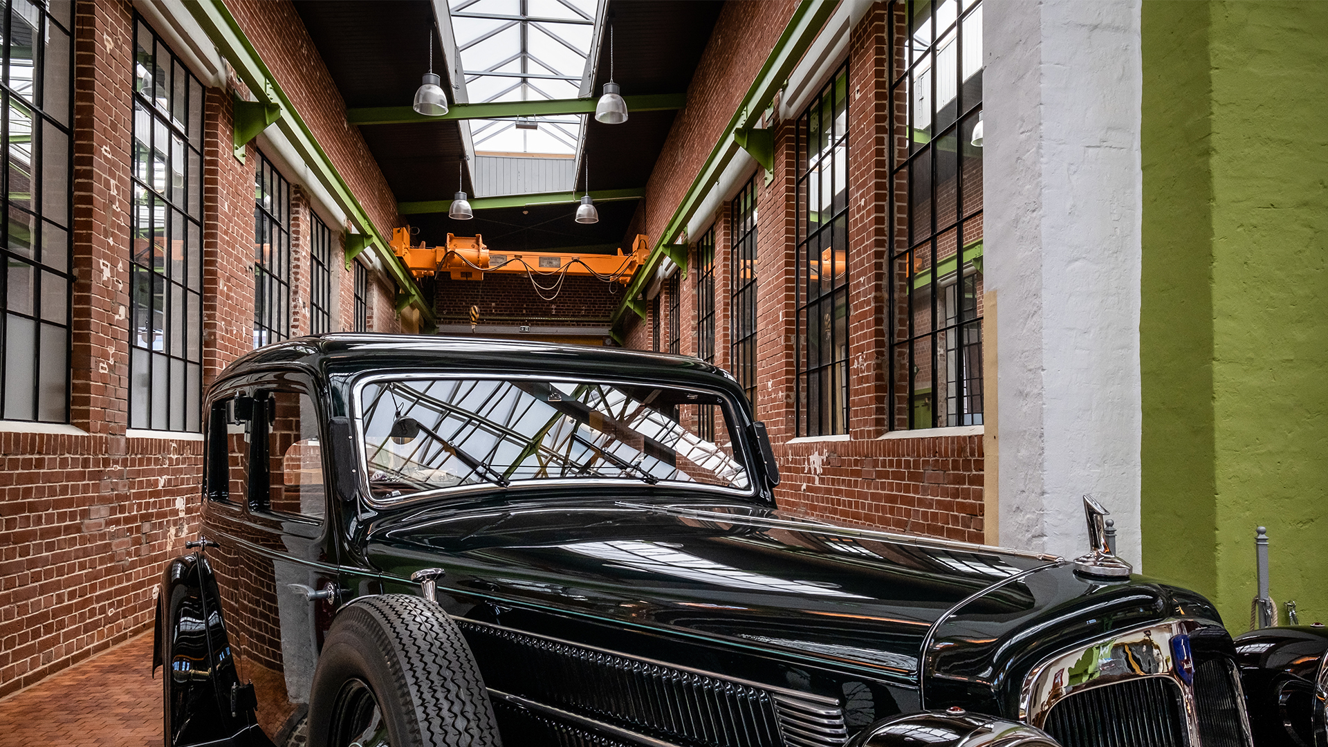 Klassisches Auto in der Eventhalle Zündmagnet in Wurzen mit historischen Backsteinwänden, großen Glasfenstern und Oberlichtern.